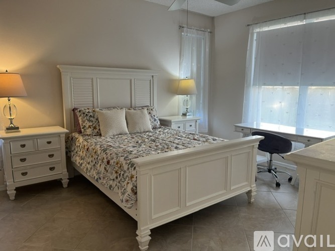 A bedroom with a bed, nightstand, and chair.
