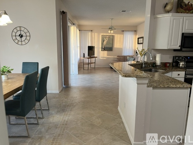 A kitchen with a dining table and chairs is shown.