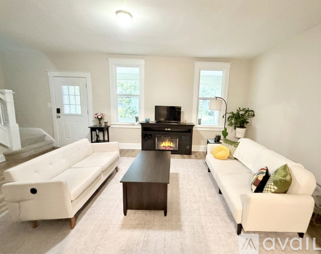 A living room with a fireplace and a white couch.