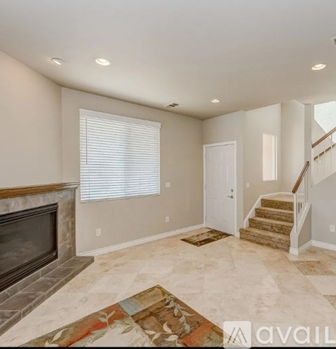 A living room with a fireplace and a rug on the floor.