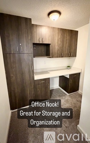 A kitchen area with wooden cabinets and a countertop is available for office use.