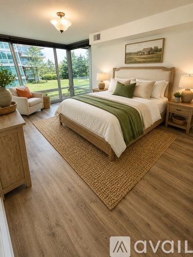A bedroom with a large bed and a view of a green lawn outside the window.