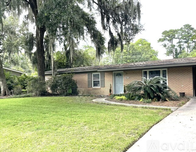 A house with a green lawn and trees in the background.