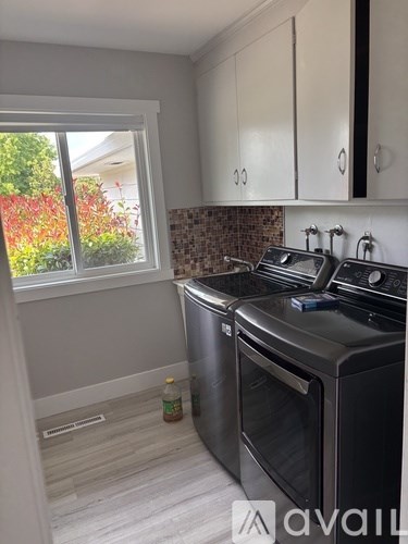 A kitchen with a black oven and white cabinets.