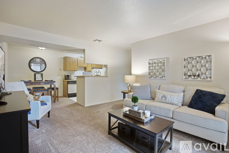 A living room with a white couch, a black coffee table, and a clock on the wall.
