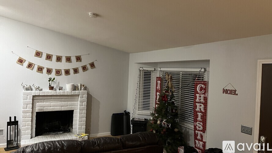A living room with a fireplace, a Christmas tree, and a sign that says "NOEL CHRISTMAS".