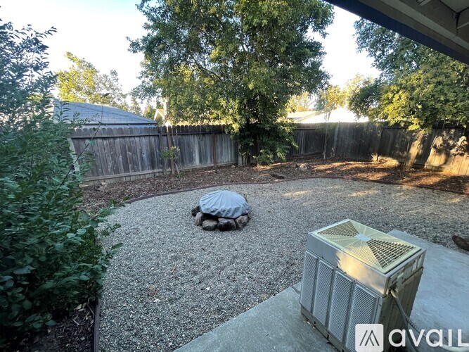 A backyard with a hot tub and a fence.