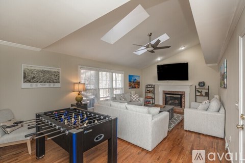 A living room with a foosball table in the middle.
