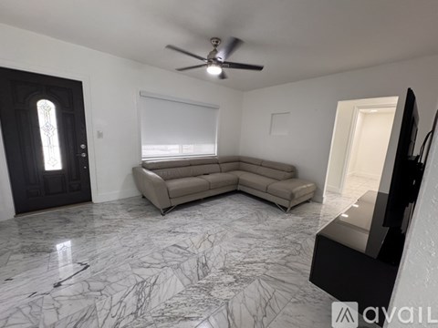 A living room with a grey sofa and a black door.