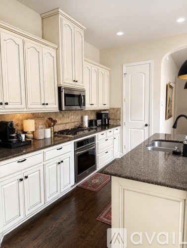 A kitchen with white cabinets and a granite countertop.