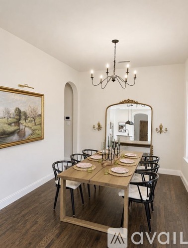 A dining room with a wooden table set for six.
