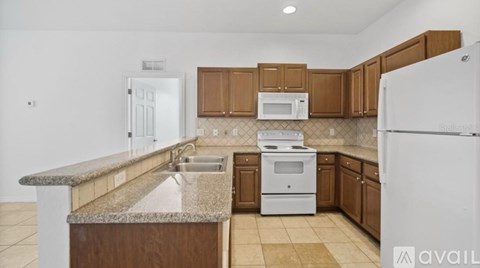A kitchen with brown cabinets and a granite counter top.