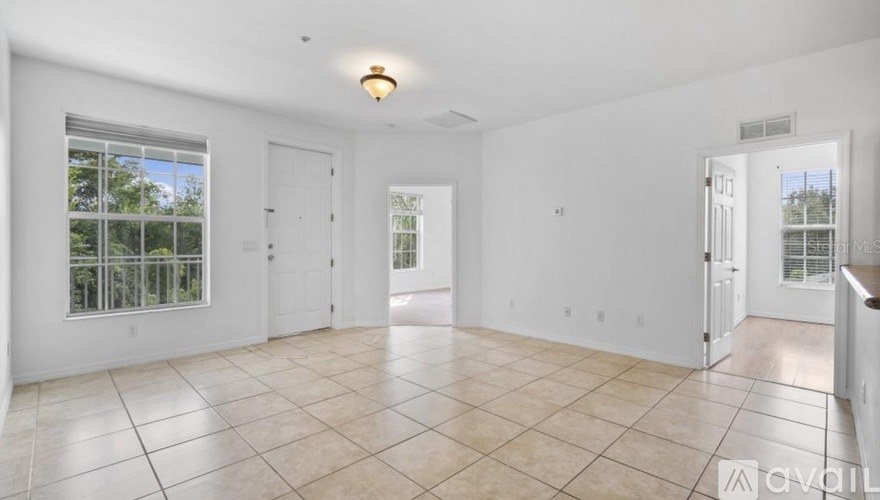 A spacious room with tiled flooring and white walls.
