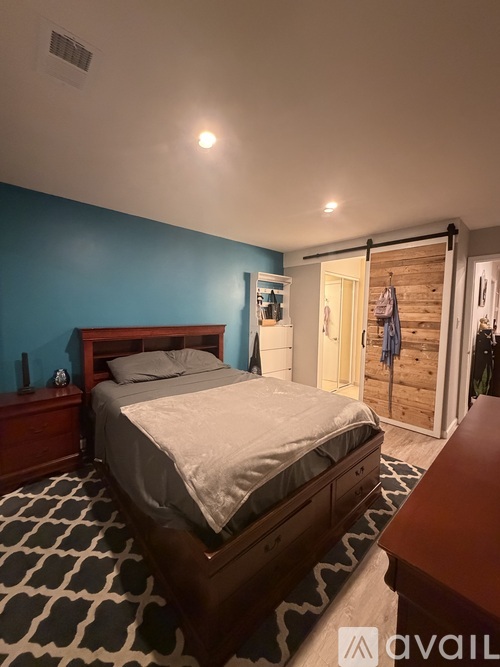 A bedroom with a bed, nightstand, and sliding door leading to a closet.