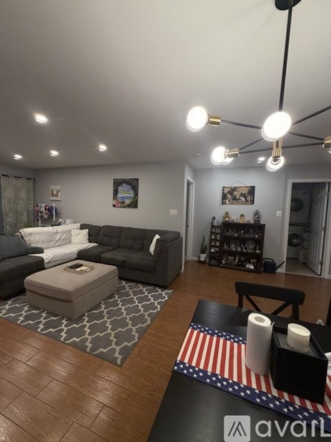 A living room with a grey couch and a coffee table with a box on it.