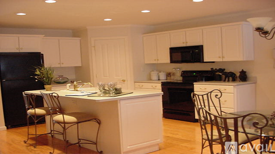 A kitchen with black appliances and white cabinets.