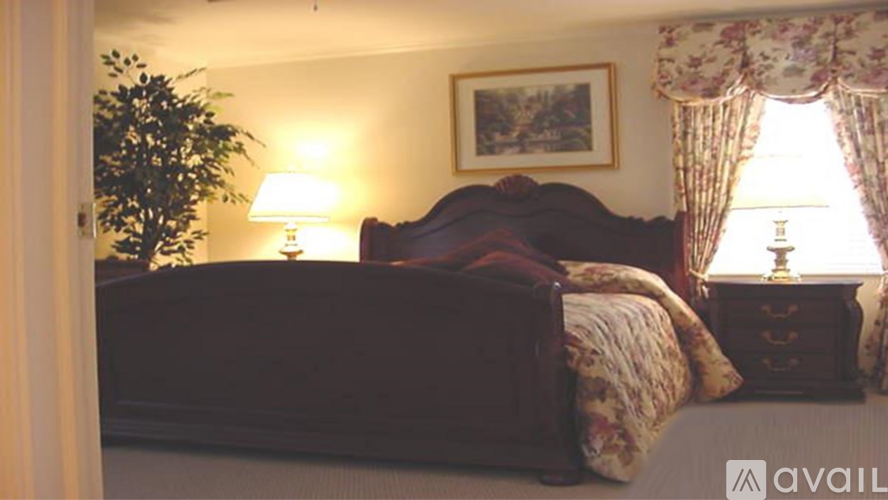 A bedroom with a bed, nightstand, and lamp.