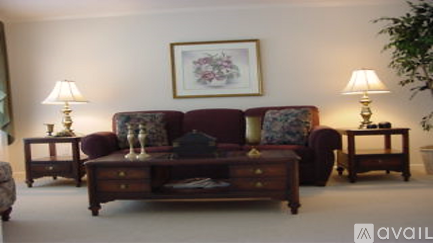 A living room with a couch, two lamps, and a painting on the wall.