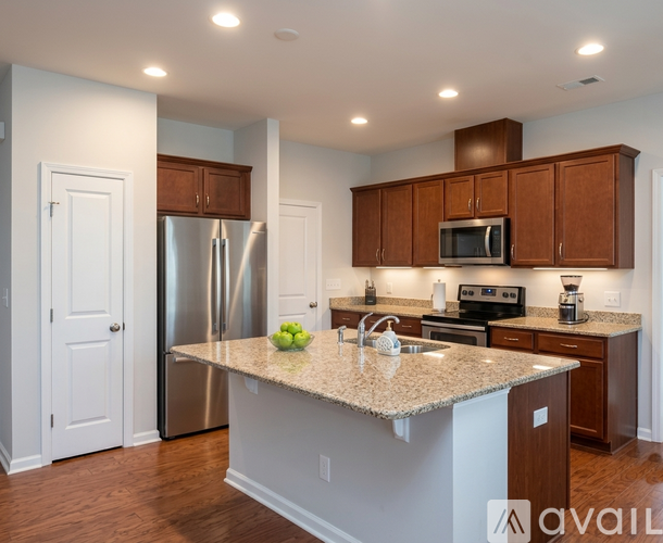 A kitchen with a granite countertop and stainless steel appliances.
