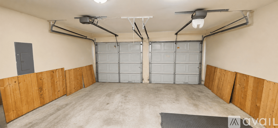 A spacious garage with a black mat on the floor and a ceiling fan.