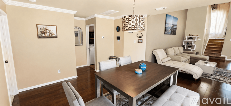 A dining room with a wooden table and chairs.