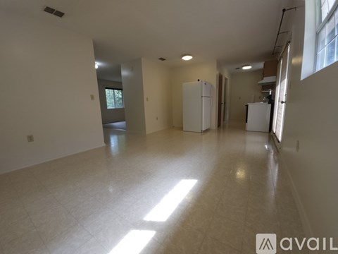 A spacious empty room with a tiled floor and white walls.