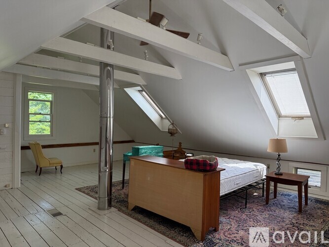 A bedroom with a bed, desk, and chair.