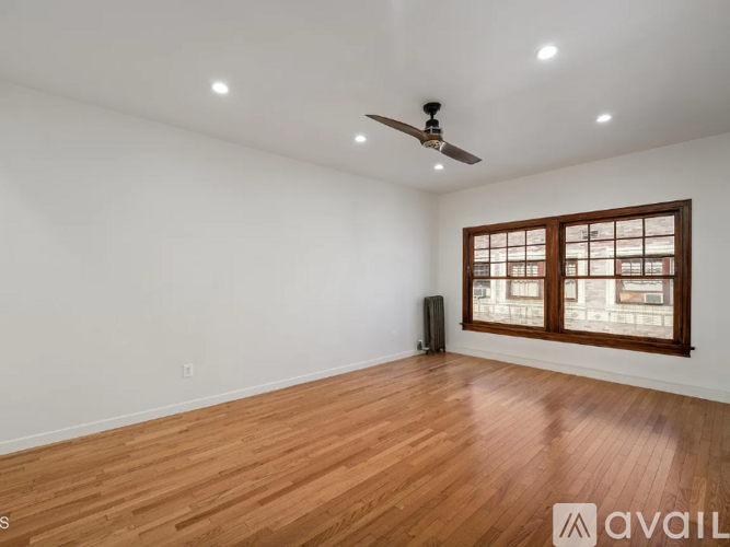 A room with wooden flooring and a ceiling fan.