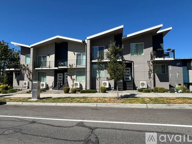 A modern apartment building with multiple balconies and doors.