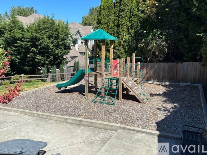 A playground with a green slide and a red climbing frame.