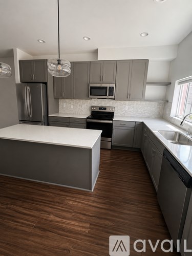 A modern kitchen with wooden floors and a large island.