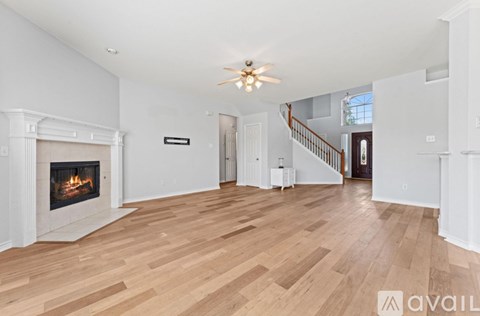 A spacious living room with a fireplace and hardwood floors.