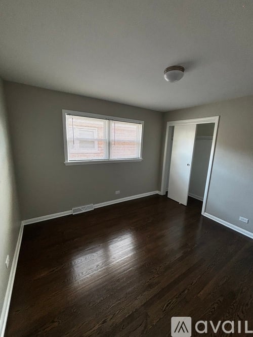 A room with a window and wooden flooring.