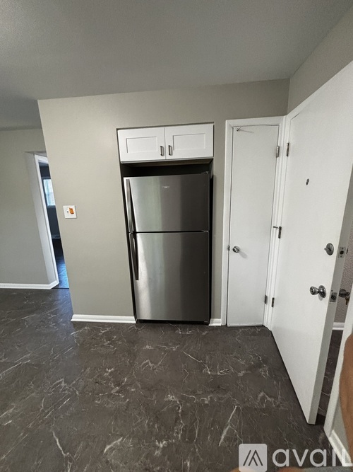 A kitchen with a stainless steel refrigerator and a white door.