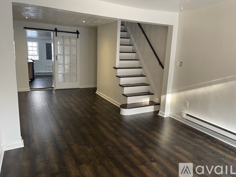 A spacious room with a staircase leading to the upper floor.