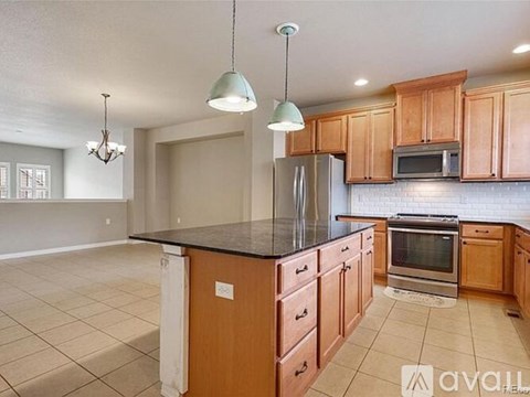A kitchen with wooden cabinets and a black countertop.