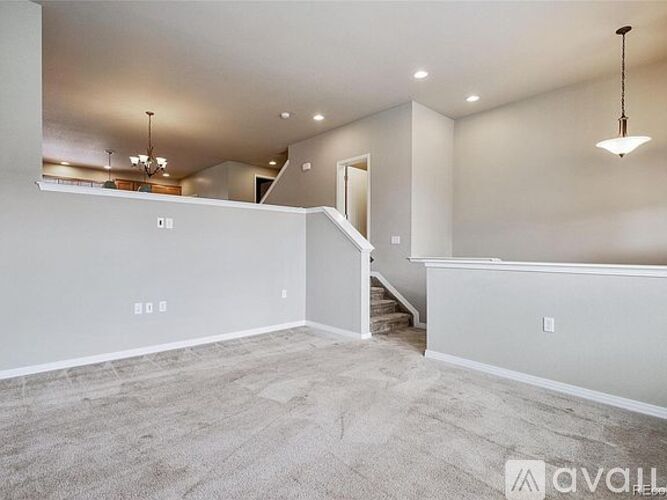 A spacious living room with a staircase leading to the upper level.