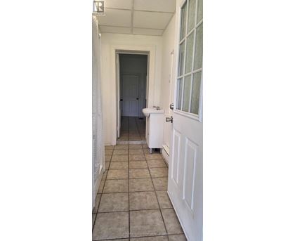 A white door is open to a dark hallway.