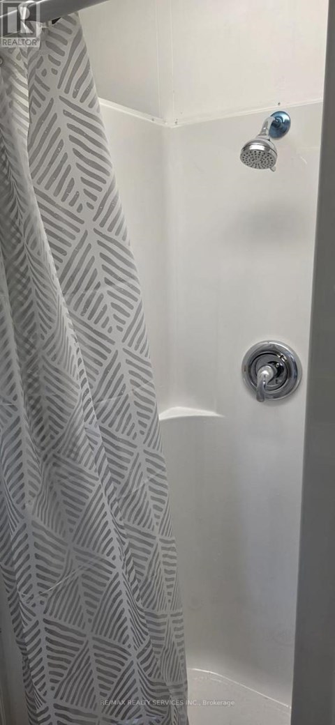 A shower curtain with a diamond pattern hangs over a bathtub.