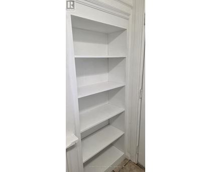 A white pantry with empty shelves.