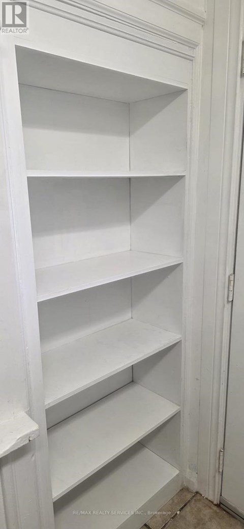 A white pantry with empty shelves.
