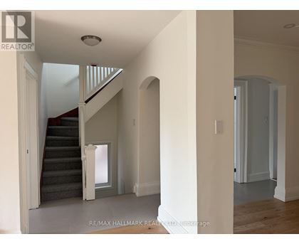 A spacious hallway with a staircase leading to the second floor.