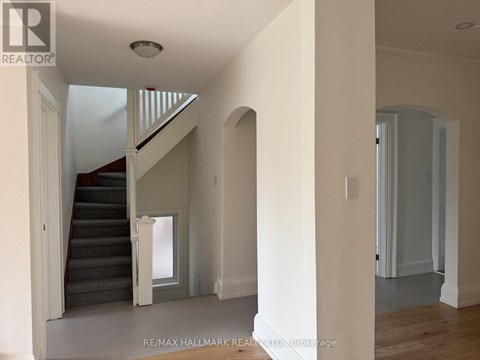 A spacious hallway with a staircase leading to the second floor.