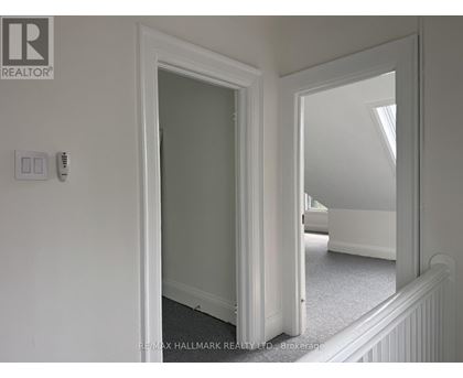 A white door with a mirror on the wall.