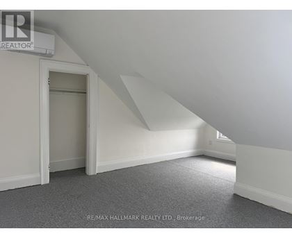 A room with a carpeted floor and a window.