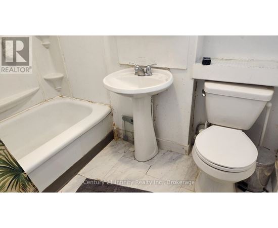 A white toilet sits next to a sink in a bathroom.