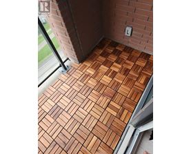 A wooden floor with a brick wall behind it.