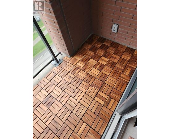 A wooden floor with a brick wall behind it.
