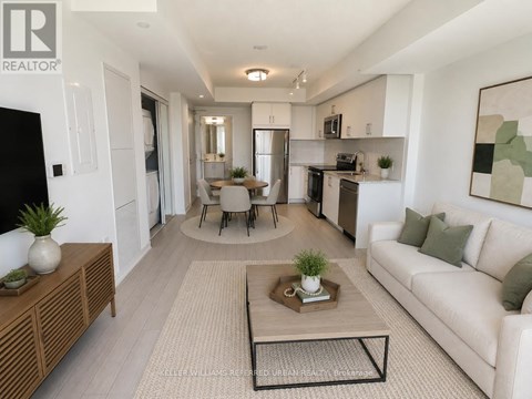 A modern living room with a white couch, a coffee table, and a dining table with chairs.