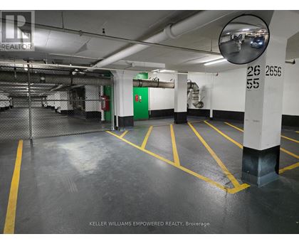 A parking garage with yellow lines on the floor.